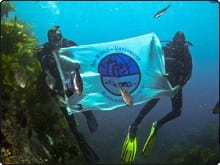 Proudly displaying their flag underwater - photo courtesy of Our World Underwater Scholarships www.owuscholarship.org